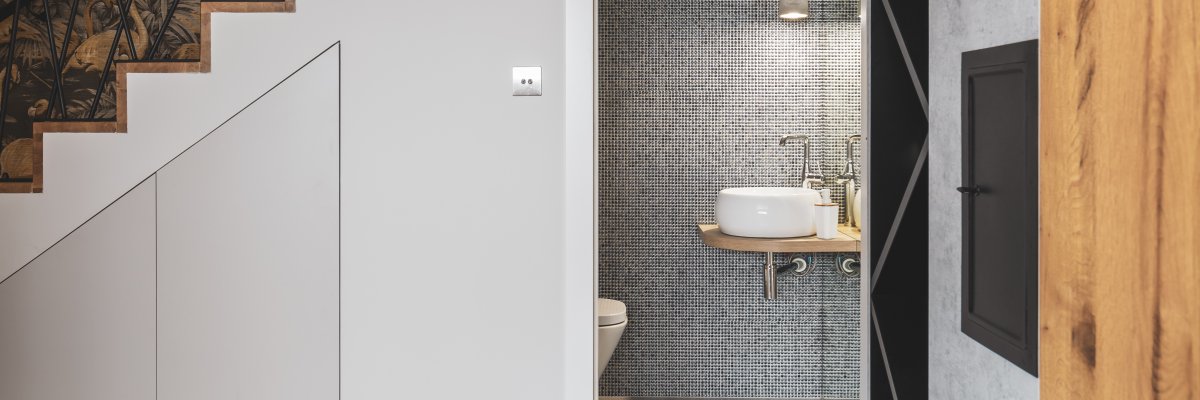 Korridor mit Treppe und offener Tür zu einem eleganten Badezimmer